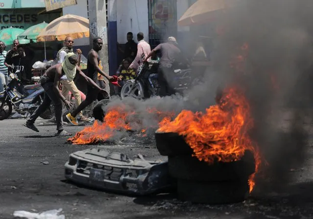 Demonstrators gather at a burning roadblock during protests over rising fuel prices and crime as inflation surged to its highest in a decade, in Port-au-Prince, Haiti on September 14, 2022. (Photo by Ralph Tedy Erol/Reuters)