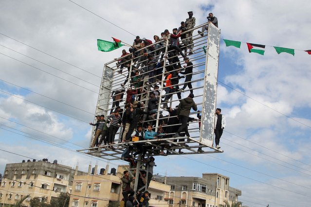 Palestinians climb on a billboard structure as they watch the handover of Or Levy, Eli Sharabi and Ohad Ben Ami, hostages held in Gaza since the deadly October 7, 2023 attack, to the Red Cross as part of a ceasefire and a hostages-prisoners swap deal between Hamas and Israel in Deir Al-Balah in the central Gaza Strip, on February 8, 2025. (Photo by Hatem Khaled/Reuters)
