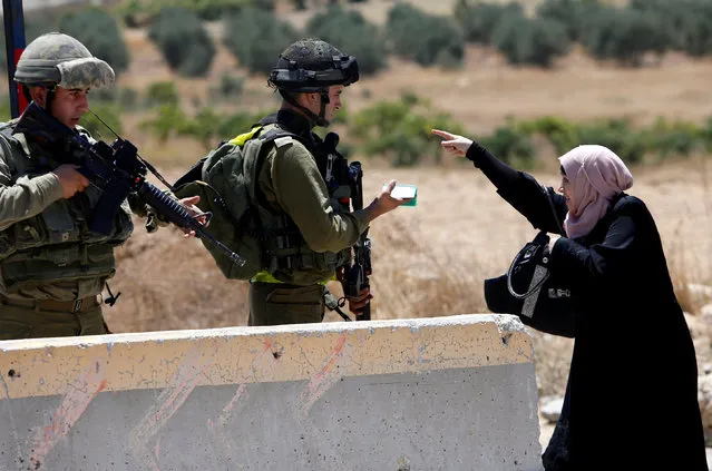 A Palestinian woman argues with Israeli army soldiers as she is searched at a checkpoint during clashes in the West Bank Al-Fawwar refugee camp, south of Hebron August 16, 2016. (Photo by Mussa Qawasma/Reuters)