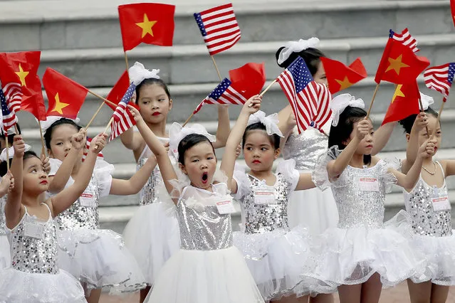 Vietnamese children wave flags before a welcome ceremony of U.S. President Donald Trump at the Presidential Palace in Hanoi, Vietnam, Sunday, November 12, 2017. (Photo by Luong Thai Linh/Pool Photo via AP Photo)