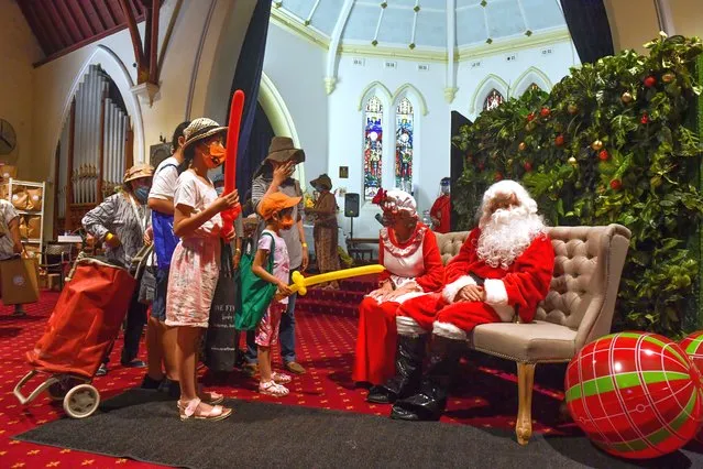 Santa Claus and Mrs Claus hand out gifts at the Rev. Bill Crews Foundation Christmas lunch in Ashfield, Sydney, Australia, 25 December 2021. The Rev. Bill Crews Foundation will give more than 2,000 takeaway meals to the homeless and needy on Christmas Day. (Photo by Mick Tsikas/EPA/EFE)