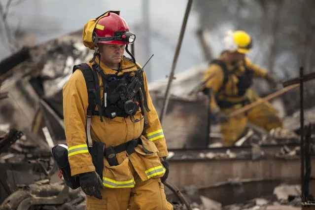 Firefighters search for victims in the rubble of a home burnt by the Valley Fire in Middletown, California, September 14, 2015. (Photo by David Ryder/Reuters)
