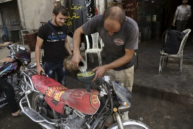A fuel vendor fills a motorcycle with locally distilled fuel in Maarat Al-Nouman, south of Idlib September 17, 2015. Picture taken September 17, 2015. (Photo by Khalil Ashawi/Reuters)