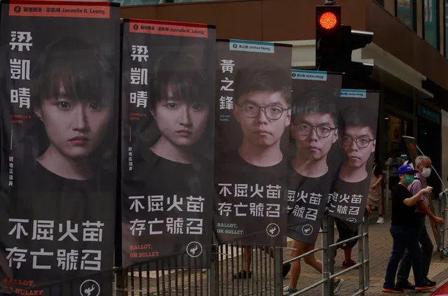 Banners of a pro-democracy candidate Joshua Wong, wearing glasses, are displayed outside a subway station in Hong Kong Saturday, July 11, 2020, in an unofficial “primary” for pro-democracy candidates ahead of legislative elections in September. (Photo by Vincent Yu/AP Photo)