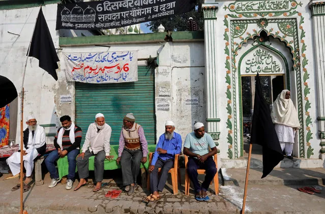 Muslims sit outside a mosque as they observe a black day marking the 25th anniversary of the razing of a 16th century Babri mosque by a Hindu mob in the town of Ayodhya, India December 6, 2017. (Photo by Pawan Kumar/Reuters)
