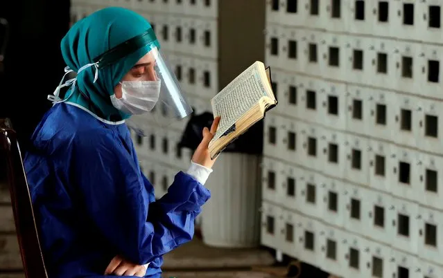 An Iranian health worker reads the Koran on Arafat day at the Tehran University Campus mosque, on July 30, 2020. Muslim pilgrims converged on Saudi Arabia's Mount Arafat for the climax of this year's hajj, the smallest in modern times and a sharp contrast to the massive crowds of previous years. (Photo by AFP Photo/Stringer)