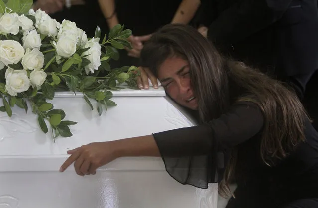 The sister of Nicole al-Helou, who was killed by the explosion Tuesday that hit the seaport of Beirut, mourns on her coffin during her funeral, in Sarba village, southern Lebanon, Thursday, August 6, 2020. French President Emmanuel Macron said an independent, transparent investigation into the massive explosion in Beirut is “owed to the victims and their families” by Lebanese authorities. During Macron's visit to the city on Thursday, angry crowds approached him and the Beirut governor as they walked through a blast-torn street. (Photo by Mohammed Zaatari/AP Photo)