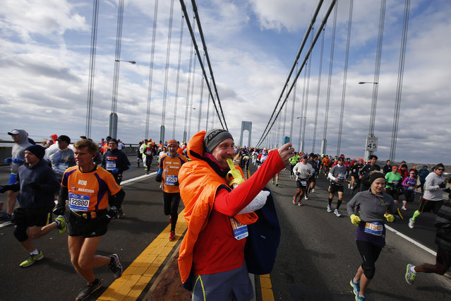 A runner stops to take a selfie as runners cross the Verrazano-Narrows Bridge at the start of the New York City Marathon, Sunday, November 2, 2014, in New York. (Photo by Jason DeCrow/AP Photo)