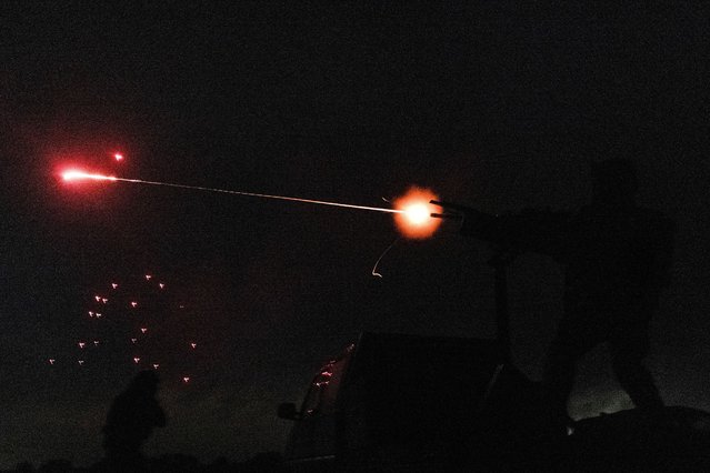 Members of a mobile air defence volunteer unit fire a machine gun and an assault rifle to shoot down an unmanned aerial vehicle during the most massive Russian drone strike, amid Russia's attack on Ukraine, in Kyiv region, Ukraine on May 18, 2025. (Photo by Stanislav Kozliuk/Reuters)