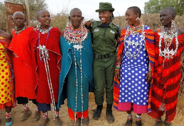 Sharon Karaine, member of Team Lioness, an all-female Kenyan ranger unit, is welcomed by Maasai women in traditional costumes as she arrives home from the Risa camp, where she stayed due to the coronavirus disease (COVID-19) outbreak, within the Olgulului conservancy in Amboseli, Kenya on August 8, 2020. (Photo by Njeri Mwangi/Reuters)