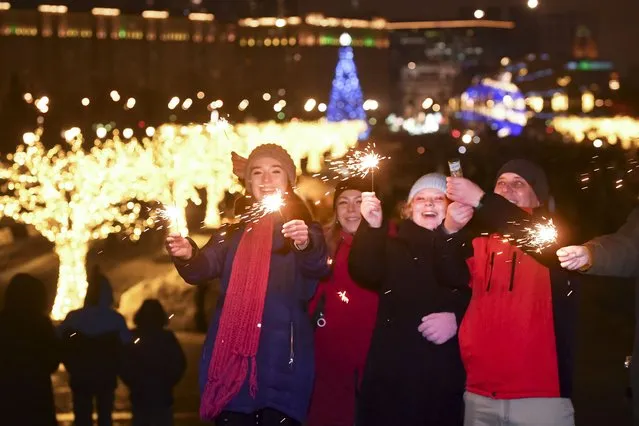 Youths celebrate the New Year in the center of Moscow, Russia, Sunday, January 1, 2023. (Photo by AP Photo/Stringer)