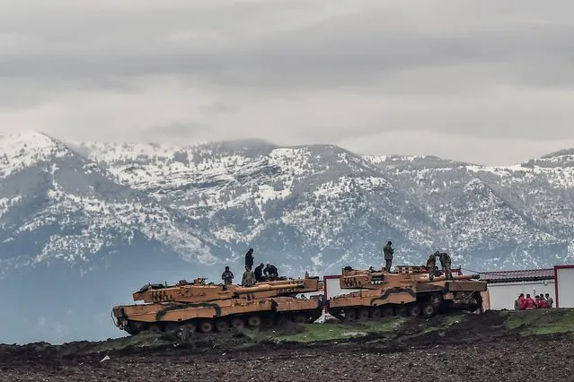 Turkish tanks are parked near the Syrian border at Hassa, in Hatay province on January 24, 2018, as part of the operation “Olive Branch”, launched a few days ago. The operation aims to oust the People's Protection Units (YPG) militia, which Turkey considers to be a terror group, from its enclave of Afrin. (Photo by Ozan Kose/AFP Photo)