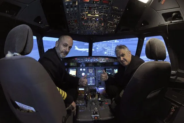 Igor Perne (L), 53, an electronic engineer and a member of the International Virtual Aviation Organisation (IVAO), and fellow virtual pilot Franc Lavric gesture for the camera before taking off on a virtual flight in a flight simulator in Nova Vas, Slovenia November 13, 2014. In 2011, Perne, a lifelong flying enthusiast, bought parts of a written-off Cyprus Airways airliner and then spent two and a half years turning the entire nose of the scrapped aircraft into an elaborate flight simulator. (Photo by Srdjan Zivulovic/Reuters)