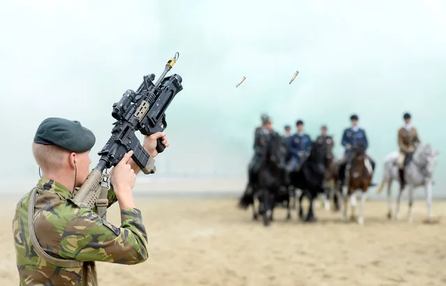 Members of the Dutch Royal Guard guide their horses through clouds of thick smoke and gunfire on the beach of Scheveningen near The Hague, the Netherlands, September 19, 2016. (Photo by Marco De Swart/Reuters)