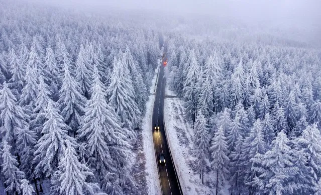 Trees are covered with snow and ice as cars drive on a road in the forests of the Taunus region in Frankfurt, Germany, Monday, December 5, 2022. (Photo by Michael Probst/AP Photo)