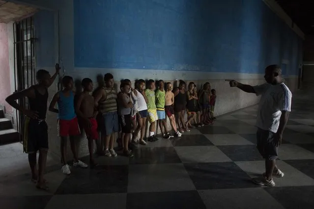 Children receive instructions from their wrestling teacher during a lesson in downtown Havana, October 20, 2014. (Photo by Alexandre Meneghini/Reuters)