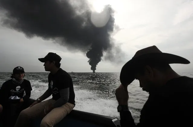 Members of the marine wildlife conservation organization Sea Shepherd monitor the fuel tanker Burgos, as it continues to burn a day after it erupted in flames off the coast of the port city of Boca del Rio, Mexico, Sunday September 25, 2016. Firefighting boats were battling the blaze aboard the Burgos, which is owned by state oil company Petroleos Mexicanos, or Pemex. Pemex said in a statement Sunday that a team of international experts in putting out fires and transferring fuel has arrived to assist. (Photo by Felix Marquez/AP Photo)