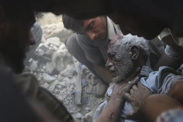 Residents carry an injured man out from the debris at a site hit by what activists claim were at least five air strikes by forces of Syria's President Bashar al-Assad in Douma, eastern al-Ghouta, near Damascus, in this September 11, 2014 file photo. (Photo by Bassam Khabieh/Reuters)