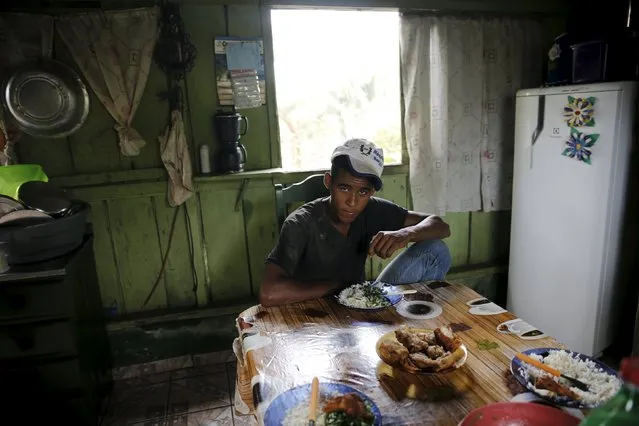 Roque sits at the table inside his house in the village of Rio Pardo next to Bom Futuro National Forest, in the district of Porto Velho, Rondonia State, Brazil, September 1, 2015. (Photo by Nacho Doce/Reuters)