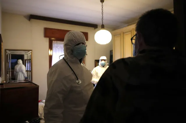 Doctor Luigi Cavanna and his nurse assistant Gabriele Cremona visit a patient in Piacenza, Italy, Wednesday, December 2, 2020. Italy recorded another 814 deaths on Friday, Dec. 4, 2020 as the toll from the COVID-19 resurgence remained stubbornly high, bringing Italy’s pandemic total to 58,842. That is the second-highest death toll in Europe, behind Britain. (Photo by Antonio Calanni/AP Photo)
