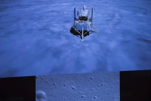In this photo released by Xinhua News Agency, a screen shows the landed Chang'e-5 spacecraft and a moon surface picture, below, taken by camera aboard Chang'e-5 spacecraft during its landing process, at Beijing Aerospace Control Center (BACC) in Beijing on Tuesday, December 1, 2020. A Chinese spacecraft landed on the moon Tuesday to bring back lunar rocks to Earth for the first time since the 1970s, the government announced. (Photo by Jin Liwang/Xinhua via AP Photo)