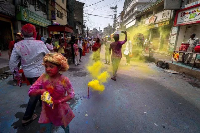 A girl throws collar powder during Holi, the festival of colors on a street in Guwahati, India, Wednesday, March 8, 2023. (Photo by Anupam Nath/AP Photo)