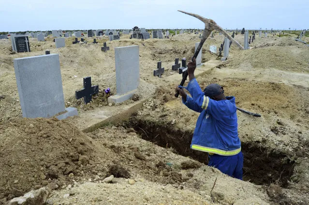 A grave digger prepares graves at the Motherwell Cemetery in Port Elizabeth, South Africa, Friday, Dec. 4, 2020. Health Minister Zweli Mkhize announced on Wednesday, December 9, 2020 that the country is now experiencing a Covid-19 pandemic second wave. (Photo by Theo Jeftha/AP Photo)