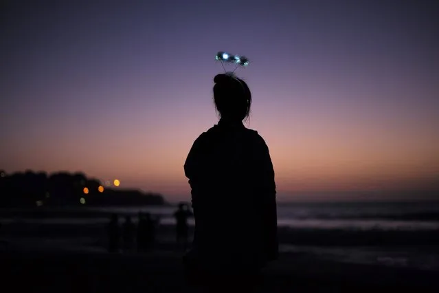 A visitor wears a flashing halo from the previous night's New Year's party as she awaits the first sunrise of 2015 on Sydney's Bondi beach, January 1, 2015. (Photo by Jason Reed/Reuters)