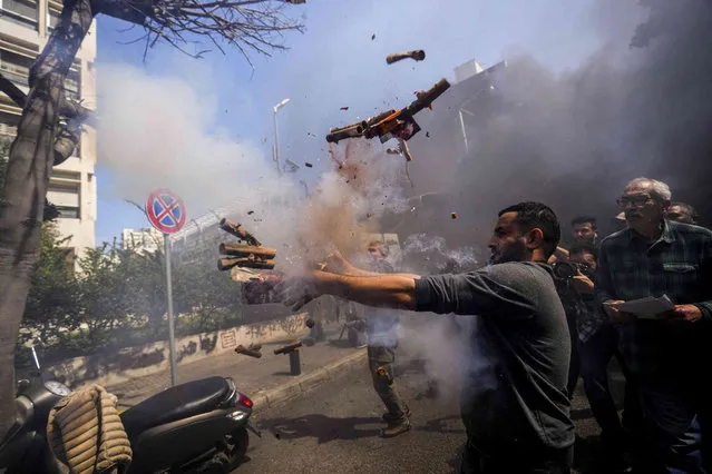 Fireworks explode in the hands of a protester launching it at the Lebanese Central Bank building as frustrated depositors rally against Central Bank's Gov. Riad Salameh, who is facing corruption charges, and the deepening financial crisis in Beirut, Lebanon, Friday, March 24, 2023. (Photo by Hassan Ammar/AP Photo)