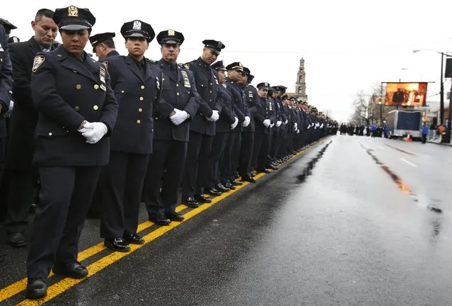 New York City police turn away from a screen showing New York Mayor Bill de Blasio speaking during the funeral service for New York Police Department officer Wenjian Liu in the Brooklyn borough of New York January 4, 2015. (Photo by Mike Segar/Reuters)