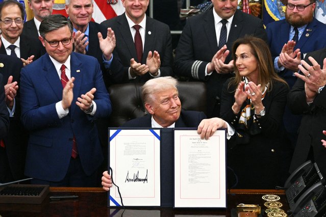 US President Donald Trump (C) shows the signed bill package to re-open the federal government as the Speaker of the House Mike Johnson (L) and other Republican leaders applaud in the Oval Office of the White House in Washington, DC, on November 12, 2025. Congress on Wednesday ended the longest government shutdown in US history, 43 days that paralyzed Washington and left hundreds of thousands of workers unpaid while Republicans and Democrats played a high-stakes blame game. The Republican-led House of Representatives voted largely along party lines to approve a Senate-passed package that will reopen federal departments and agencies, as many Democrats fume over what they see as a capitulation by party leaders. (Photo by Brendan Smialowski/AFP Photo)
