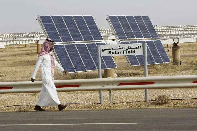 A Saudi man walks on a street past a field of solar panels at the King Abdulaziz city of Sciences and Technology, Al-Oyeynah Research Station in this May 21, 2012 file photo. Saudi Arabia's ambitious plans to become a world leader in installed solar power appear to have run into the sand amid disagreements over their scale, ownership and technology. Photo by Fahad Shadeed/Reuters)