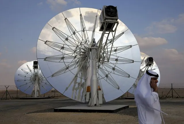 A man speaks on the phone as he walks past solar panels at the Mohammed bin Rashid Al Maktoum Solar Park in Dubai, November 28, 2015. Dubai will spend billions of dollars on generating clean energy, the government said on Saturday, aiming to have solar panels installed on the roofs of all buildings by 2030. (Photo by Reuters/Stringer)