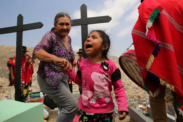 People dance as they visit tombs of relatives at “Nueva Esperanza” (New Hope) cemetery during the Day of the Dead celebrations in Villa Maria del Triunfo on the outskirts of Lima , Peru, November 1, 2016. (Photo by Mariana Bazo/Reuters)
