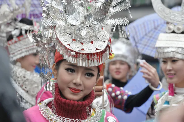 Women wearing the traditional costumes of Miao people parade in Fenghuang’s ancient city in Xiangxi, China on December 2, 2015. (Photo by Xinhua/Barcroft Media)