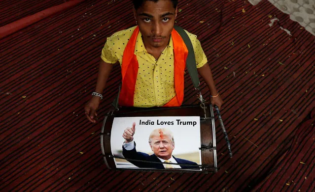 A member of Hindu Sena, a right-wing Hindu group, plays a drum with U.S. Republican presidential nominee Donald Trump’s picture on it as they symbolically celebrate his victory in the upcoming U.S. elections, in New Delhi, India, November 4, 2016. (Photo by Adnan Abidi/Reuters)
