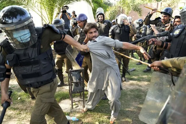 Police detain a supporter of Pakistan's former Prime Minister Imran Khan who with others are protesting against the arrest of their leader, in Lahore, Pakistan, Wednesday, May 10, 2023.  Khan can be held for eight days, a court ruled Wednesday, a day after the popular opposition leader was dragged from a courtroom and arrested on corruption charges, deepening the country's political turmoil. (Photo by K.M. Chaudary/AP Photo)