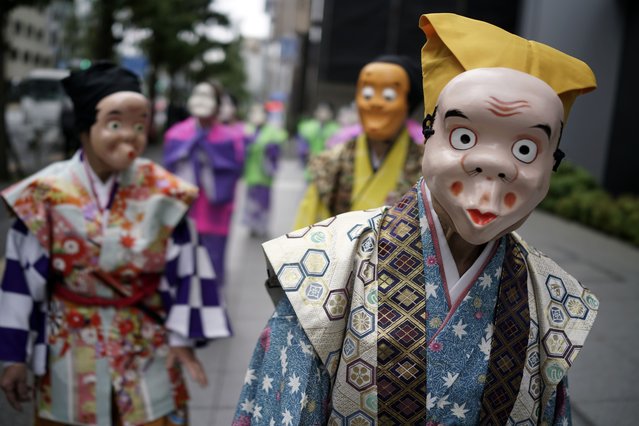 Artists wearing traditional clown masks prepare to march during the annual Shinto festival called the Grand Festival at the Kotohiragu shrine in the Toranomon business district of Tokyo, Thursday, October 10, 2024. (Photo by Eugene Hoshiko/AP Photo)