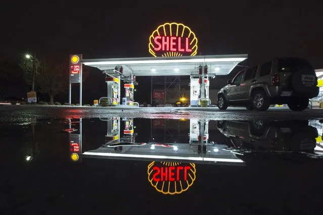A vintage Shell sign is seen illuminated at a Shell gas station in Cambridge, Massachusetts December 12, 2014. (Photo by Brian Snyder/Reuters)