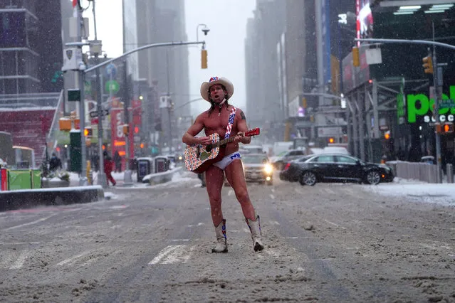 Robert Burck, better known as the “Naked Cowboy” poses for photos in the snow in Times Square amid the coronavirus disease (COVID-19) pandemic in the Manhattan borough of New York City, New York, U.S., February 18, 2021. (Photo by Carlo Allegri/Reuters)