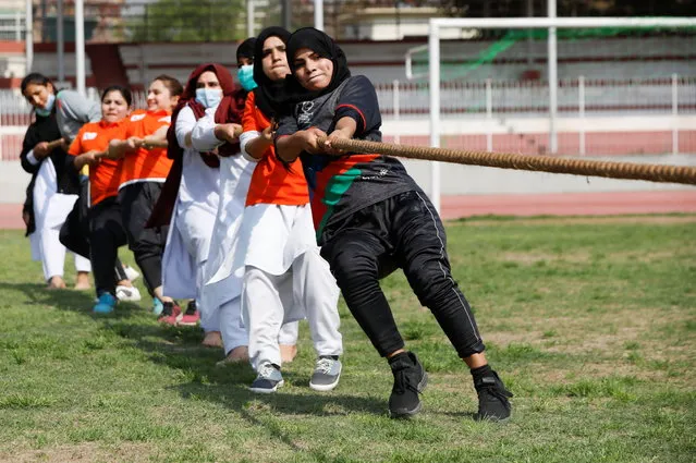 Women participants react as they pull a rope during a sports event in connection with the International Women's Day celebrations in Peshawar, Pakistan on March 8, 2021. (Photo by Fayaz Aziz/Reuters)