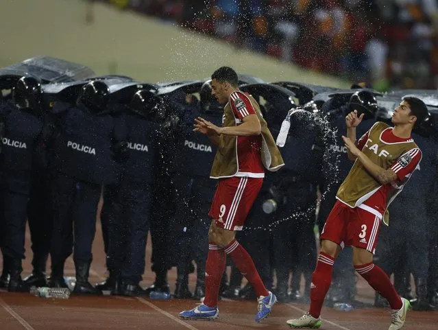 Equatorial Guinea's players dodge water bottles thrown by fans as police protect Ghana players during their semi-final soccer match of the 2015 African Cup of Nations in Malabo, February 5, 2015. (Photo by Amr Abdallah Dalsh/Reuters)