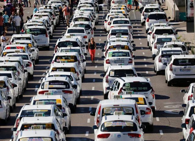 Taxis block a section of the main avenue Paseo de la Castellana during an indefinite strike against what they say is unfair competition from ride-hailing and car-sharing services such as Uber and Cabify, in Madrid, Spain, July 31, 2018. (Photo by Paul Hanna/Reuters)