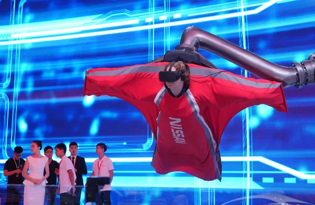 A visitor tries out a virtual reality suit during the International Automobile Exhibition in Guangdong, China on November 22, 2016. (Photo by Imaginechina/Rex Features/Shutterstock)