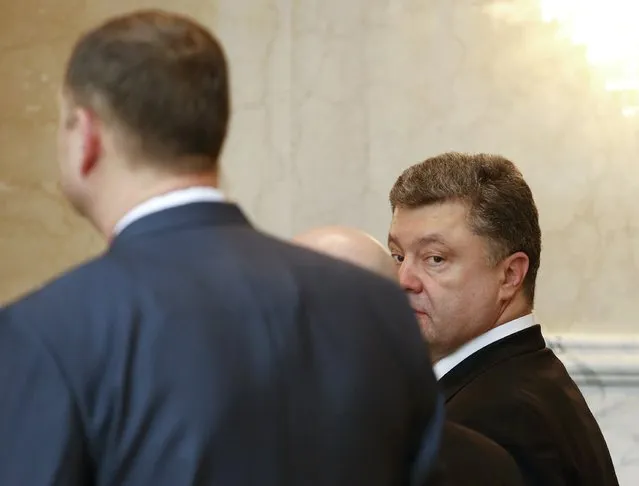 Ukraine's President Petro Poroshenko (R) looks on as he attends a peace summit to resolve the Ukrainian crisis in Minsk, February 12, 2015. (Photo by Grigory Dukor/Reuters)