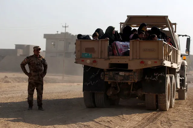 Displaced Iraqi people who left their homes ride in a military vehicle of Iraqi security forces during a battle with Islamic State militants in Mosul, Iraq, November 29, 2016. (Photo by Khalid al Mousily/Reuters)