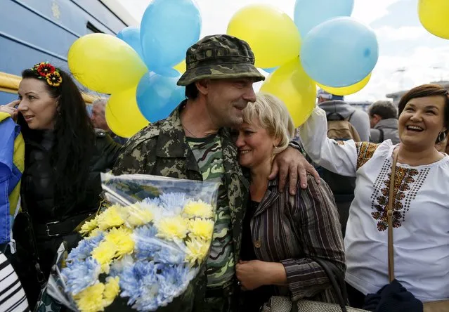 A Ukrainian serviceman embraces his wife after returning from the frontline in the eastern regions, at a railway station in Kiev, Ukraine, September 9, 2015. (Photo by Gleb Garanich/Reuters)