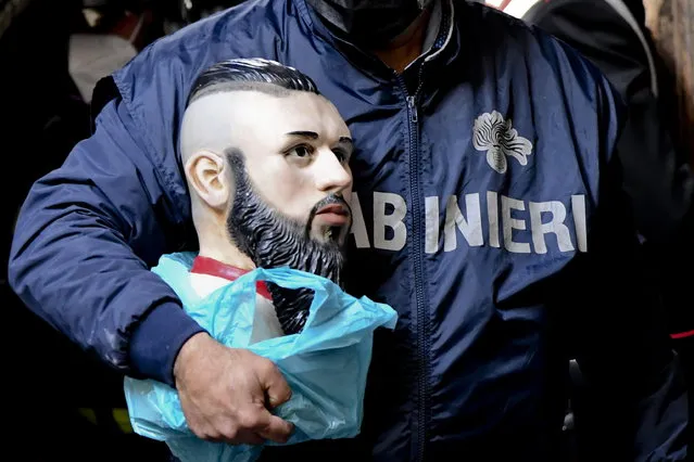 A carabiniere officer removes the bust containing the ashes of the “baby boss” Emanuele Sibillo, killed in a Camorra ambush, from the votive chapel in the historic center building in Naples, Italy, 28 April 2021. The ashes of a Neapolitan Camorra mafia “youth boss” slain in 2015 at the age of 20 have been found in an altar in a private resident in Naples, police said on 28 April after removing several tributes to the cult mafia figure in the southern Italian city. Emanuele Sibillo was a leader of the Camorra's “paranza dei bambini” (“trawler of children”) or Piranhas, used by the local mob for many illegal activities including murder. (Photo by Ciro Fusco/EPA/EFE)