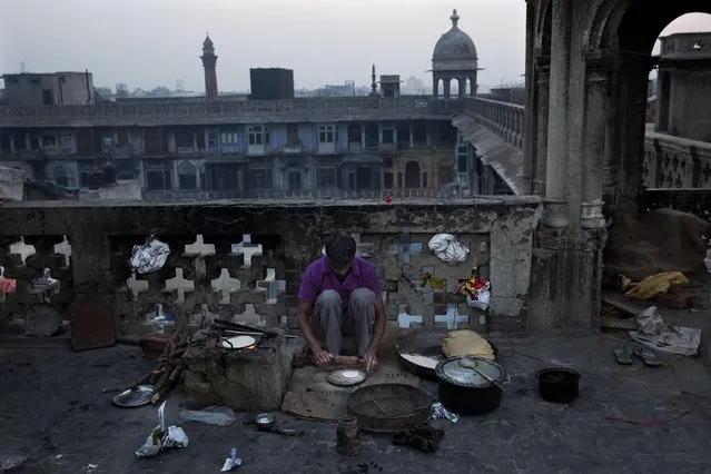 An Indian man prepares flatbread in the old city area of New Delhi, India, Wednesday, February 11, 2015. Old Delhi, founded by Mughal Emperor Shah Jahan in the 17th Century, is today a dilapidated version of its former glory when it was the capital city of the Mughals and filled with mosques, gardens, mansions of nobles and members of the royal court. (Photo by Bernat Armangue/AP Photo)