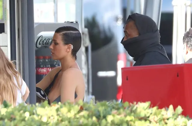 The American Hip Hop Rapper Kanye West and his partner Bianca Censori continue their European holiday in Italy on August 22, 2023. The pair were seen stopping at a vending machine for some snacks as Bianca stunned wearing a nude coloured body suit whilst Kanye tries to go incognito wearing a black coat and trying to hide his face. The couple then went on to a kiosk as they grabbed bottles of Coca-Cola and Fanta before being spotted enjoying dinner at a restaurant and were all smiles enjoying each other's company at the dining table. (Photo by Backgrid UK)